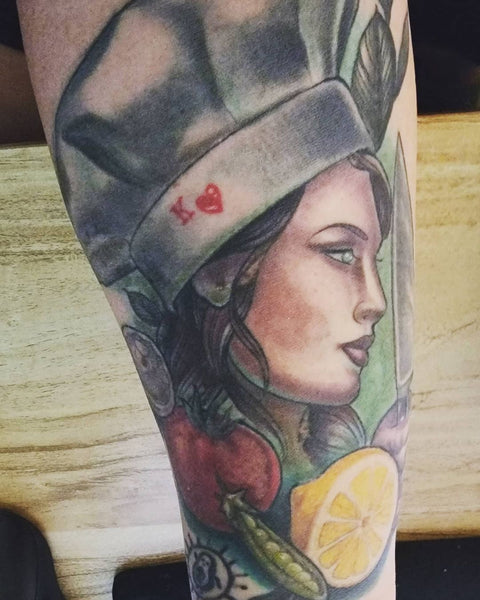 Tattoo of a female chef wearing a traditional white chef hat 