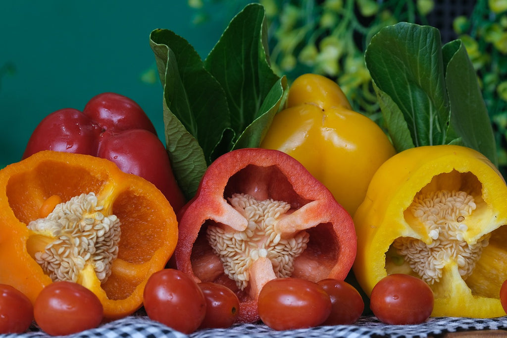 Fresh bell peppers sliced in half with snow cabbage and cherry tomatoes.