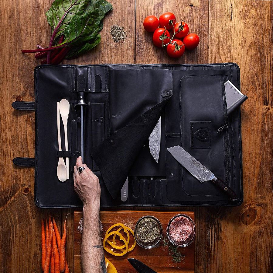Black Dalstrong Knife roll with knives, spatulas, and other kitchen tools inside.