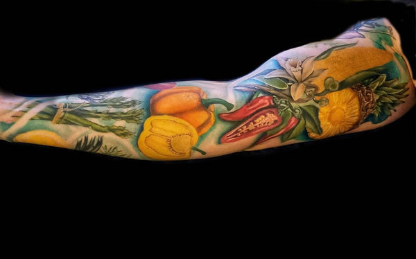 A colorful sleeve tattoo representing several vegetables 