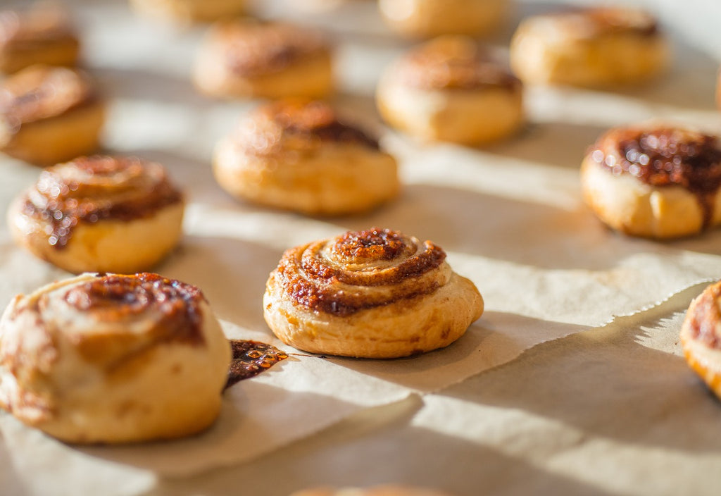 Cinnamon buns on a parchment paper cooled down, fresh from the oven.