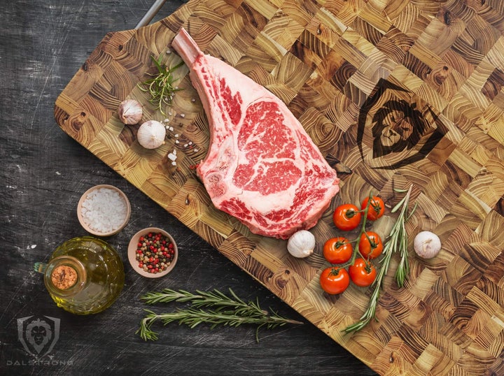 cutting board with raw steak and various veggies