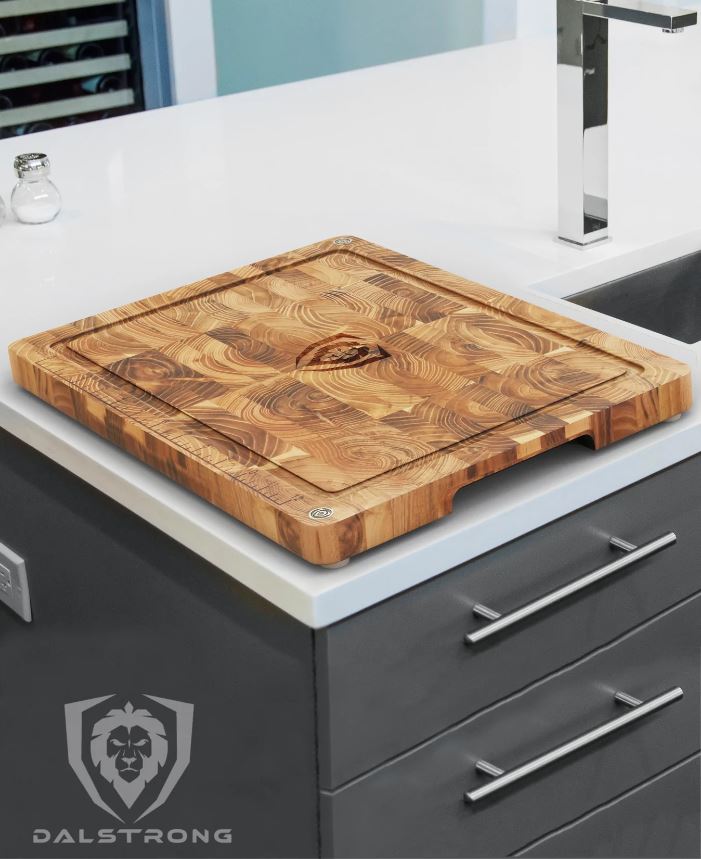 Dalstrong Medium-sized teak cutting board on top of a stunning white countertop