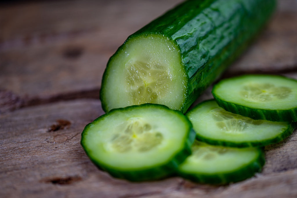 Slices of cucumber on a wooden surface.