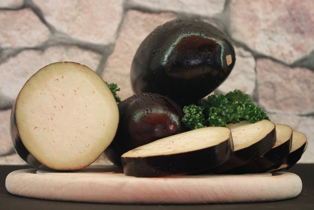 Slices of eggplant on top of a wooden board.