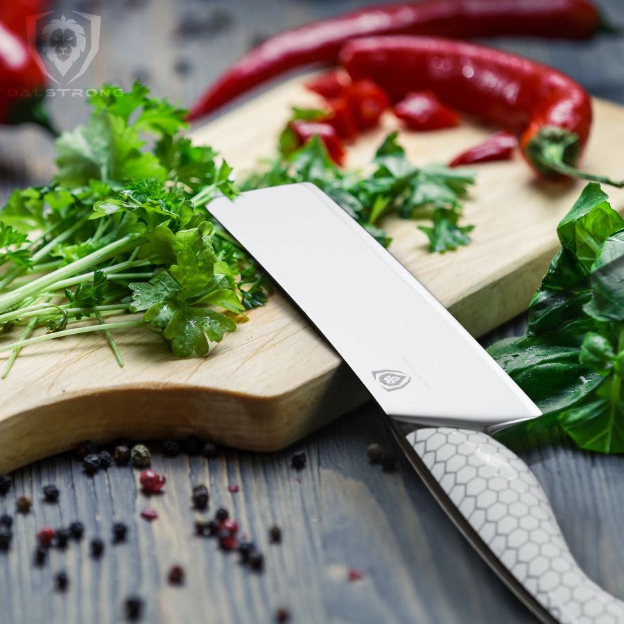 Dalstrong Frost Fire Nakiri knife on a wooden chopping board used for chopping fresh cilantro and chili