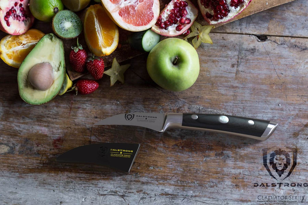 Apples pears and other fruit next to a paring knife with a black handle