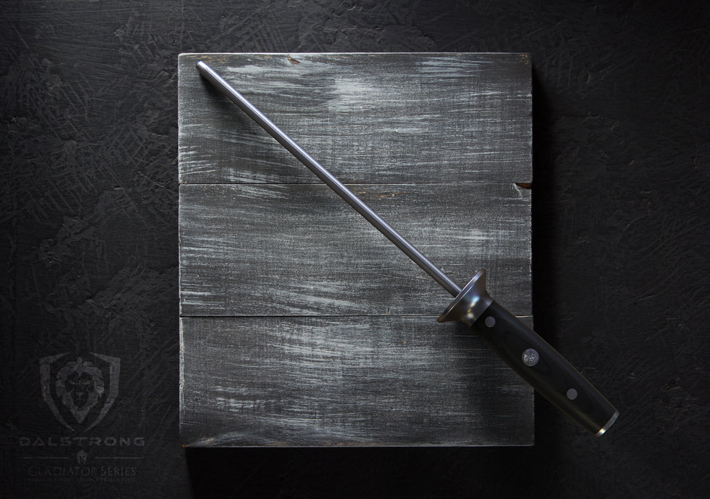 Dalstrong Gladiator Series Honing Rod Resting on a dark grey cutting board with a black background. 