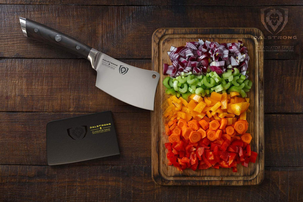 Mini cleaver with black handle next to a cutting board filled with chopped vegetables of different colors