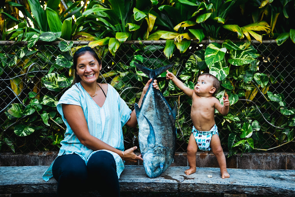 Kimi Werner holding large fish as her son Buddy stands close