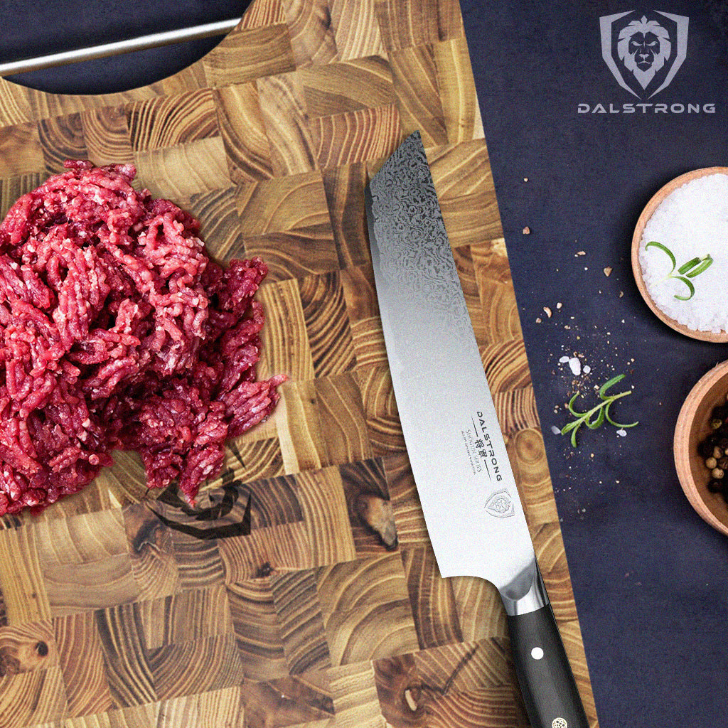 Fresh raw ground beef getting prepped for cooking on a Dalstrong teak cutting board with a Shogun Series knife next to it.