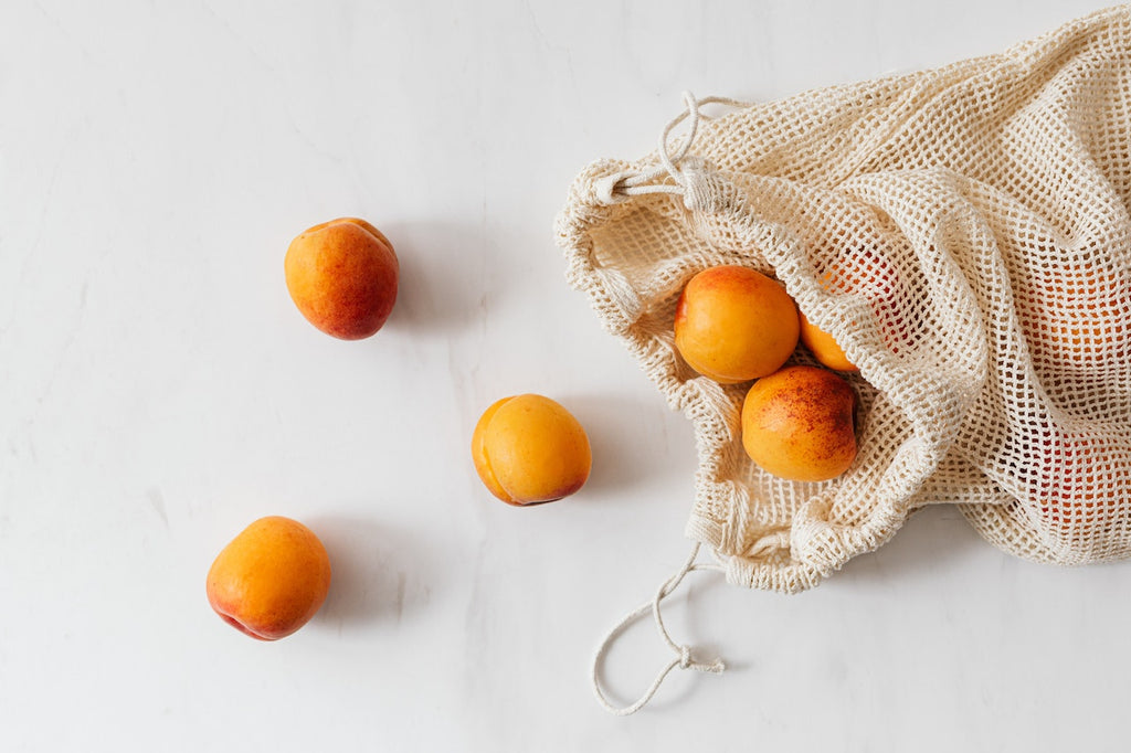 Peaches inside a bag on a white background