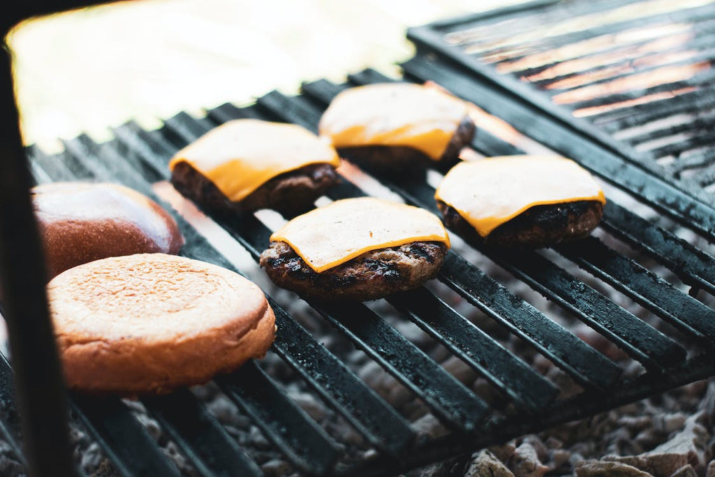 A cinematic shot of Bread and Burger Patties With Cheese on a Griller