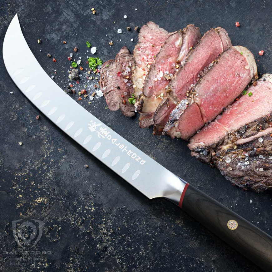 Phantom series butcher knife laying on a rock surface beside slices of briskets