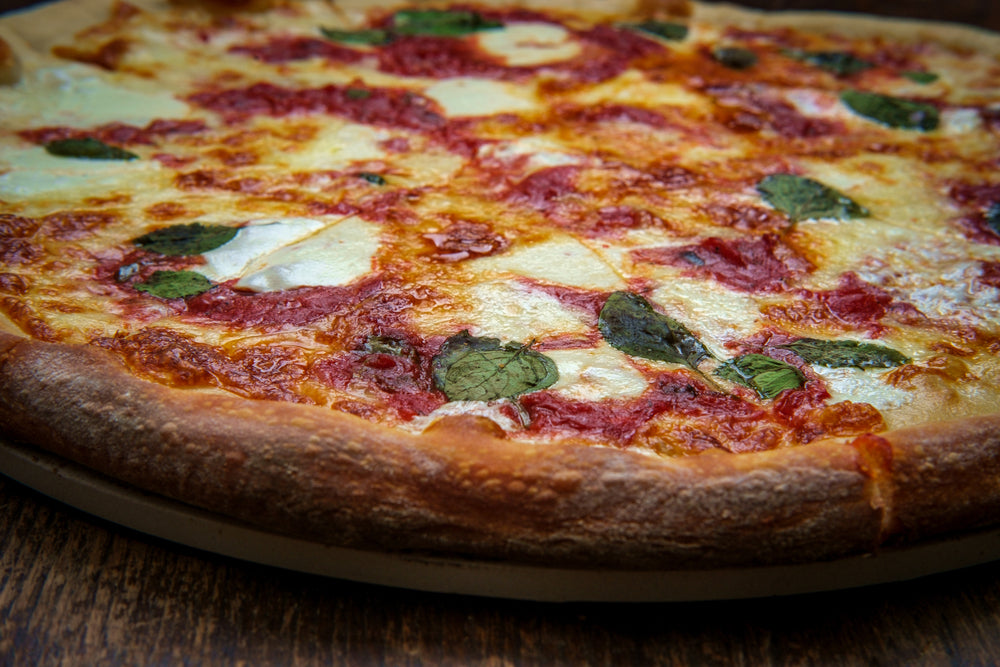 New York style Margherita pizza with fresh mozzarella and basil leaves