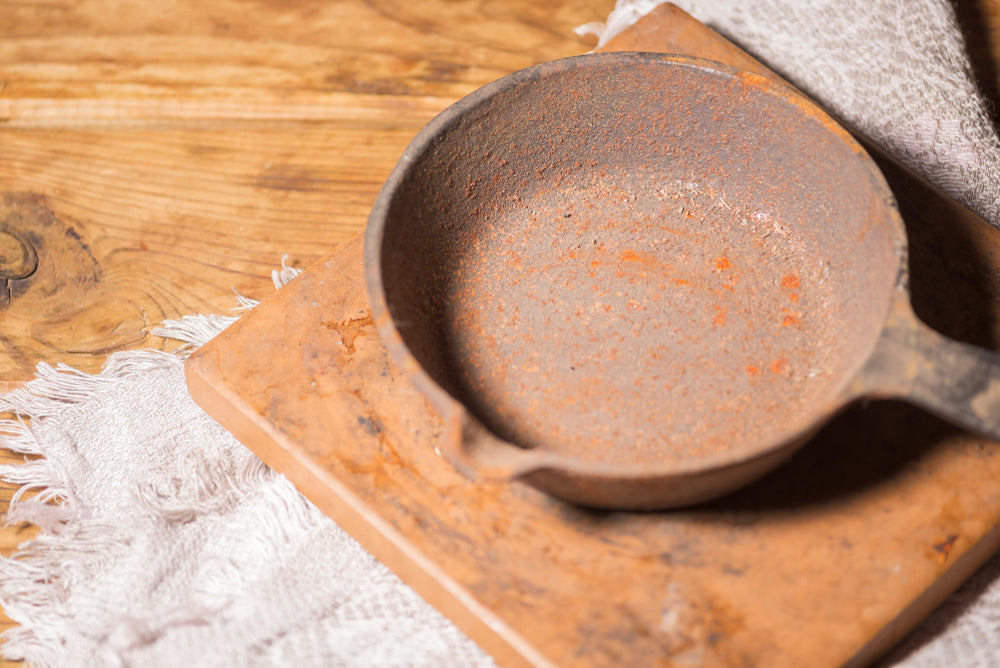 old empty cast iron pan. rusty dishes on the table