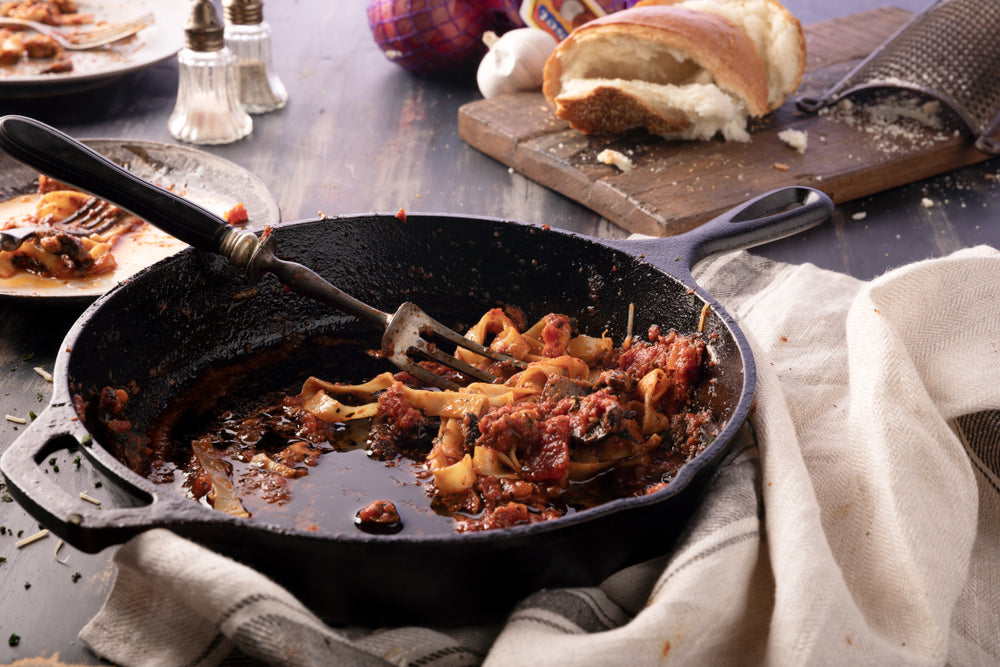 Mess after leftover meal eating Pasta Fettuccine and meatball casserole in cast iron skillet