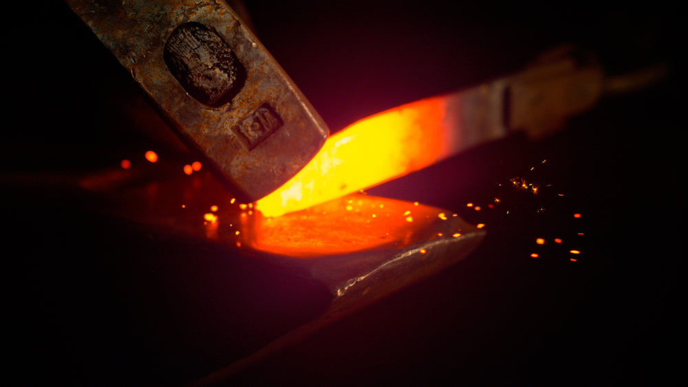 A steel knife being forged in by a blacksmith