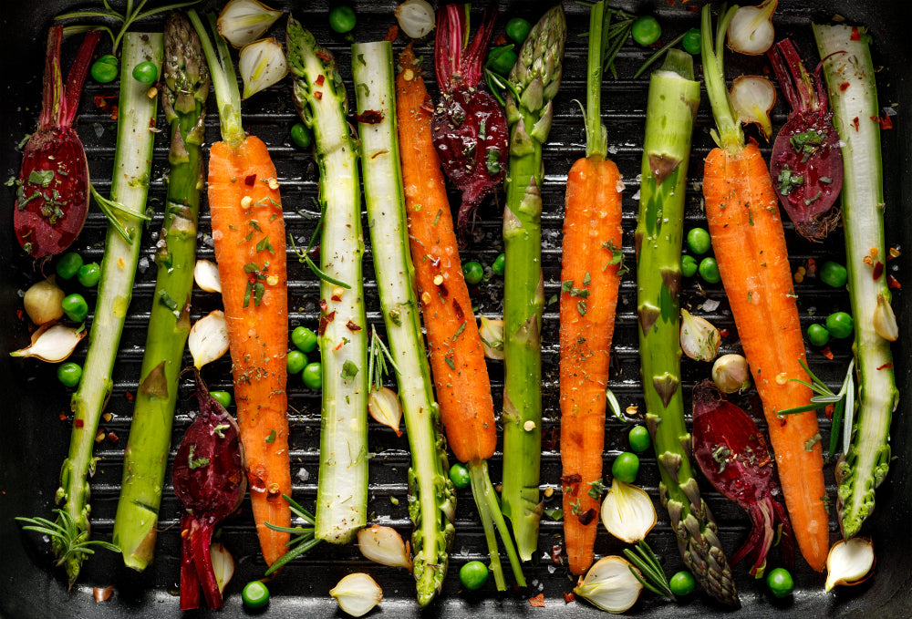 An assortment of seasoned vegetables on on top of a cooking grill