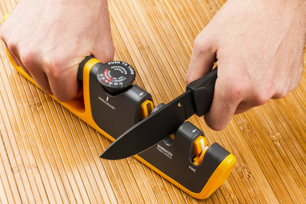 Adjustable manual knife sharpener on wooden background