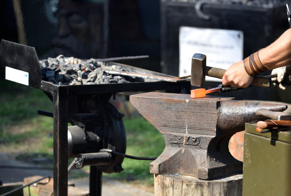 Man forges damascus steel by hand outdoors