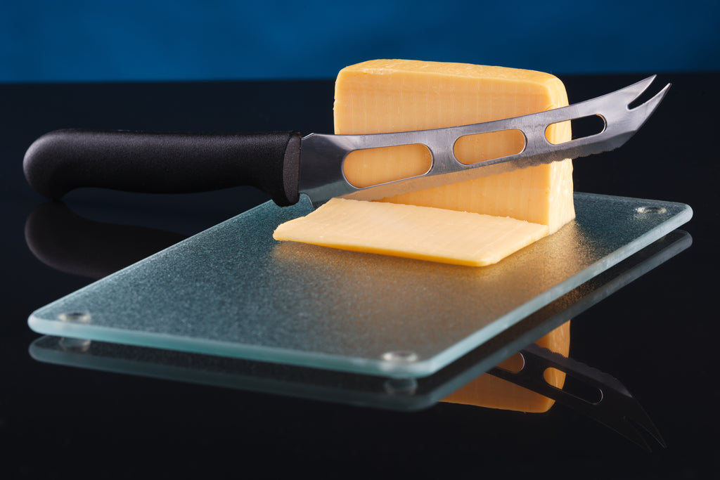 Glass cutting board with cheese and cheese knife