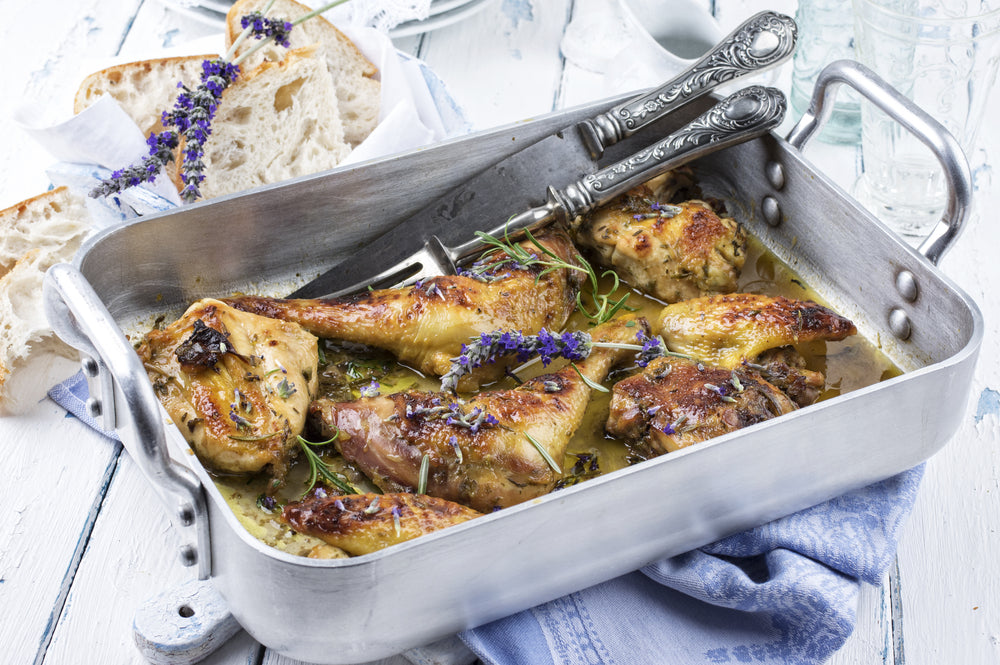 roasting pan with chicken laying on wood table