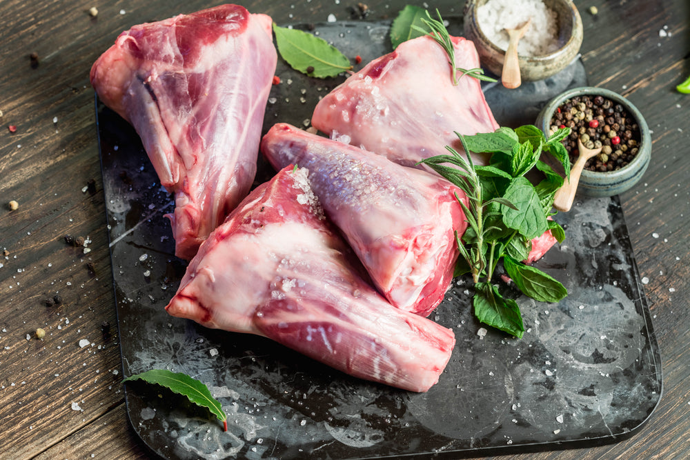 raw lamb shanks on serving board