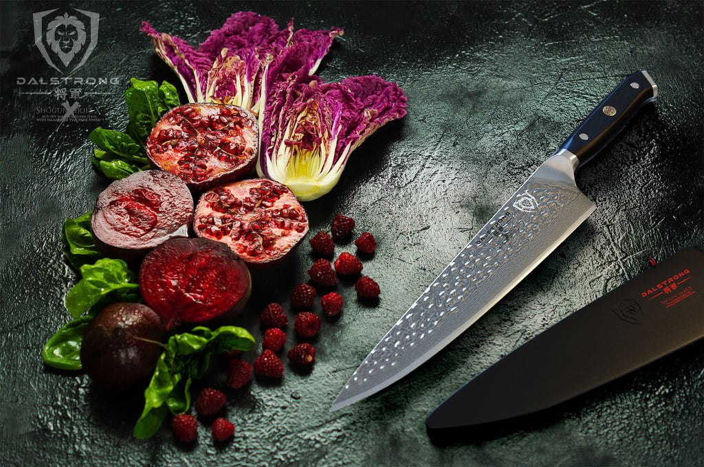 damascus kitchen knife beside sliced pomegranate 