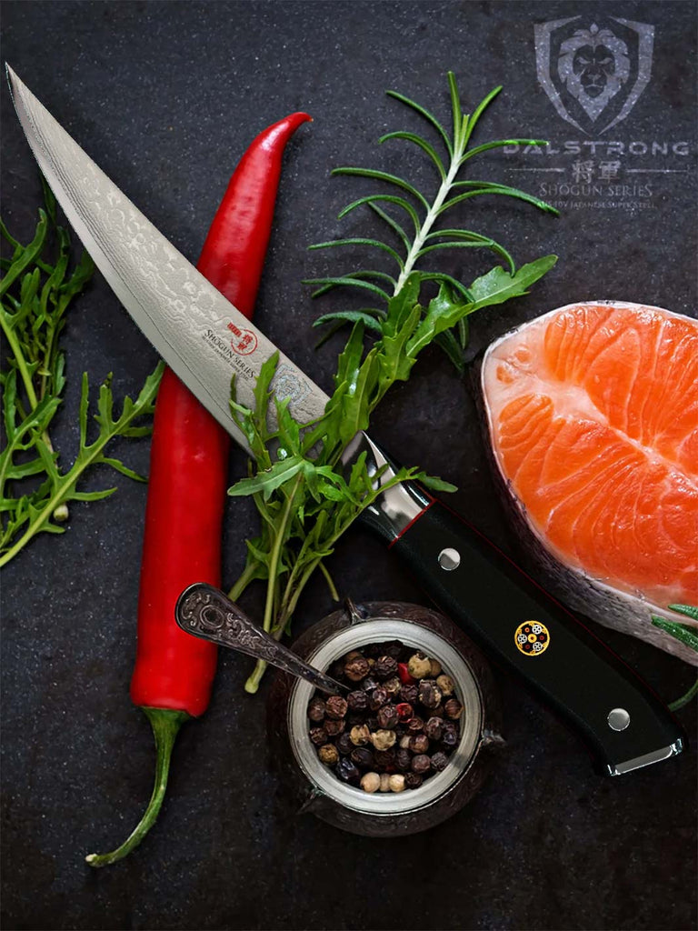 A close-up photo of the Fillet Knife 6" | Shogun Series ELITE | Dalstrong with a fillet of salmon and chilli