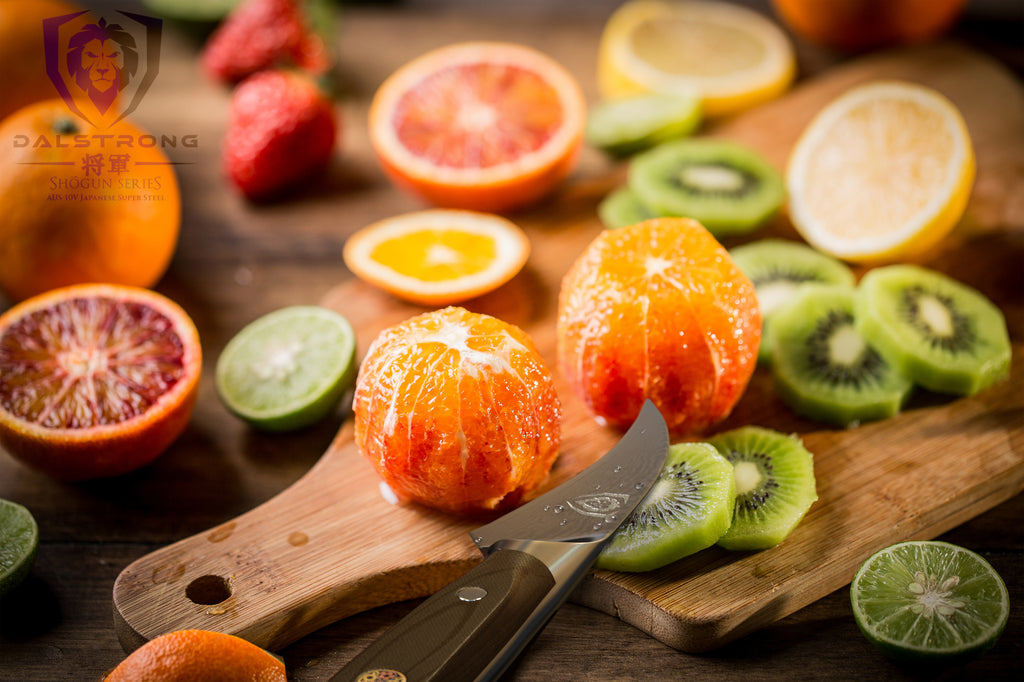 A small peeling paring knife surrounded by skinless fruit such as oranges and kiwis