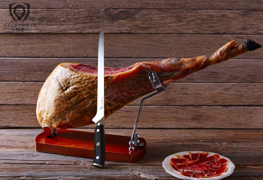 A stylish slicing knife balances on a leg of pork that is presented on a stand