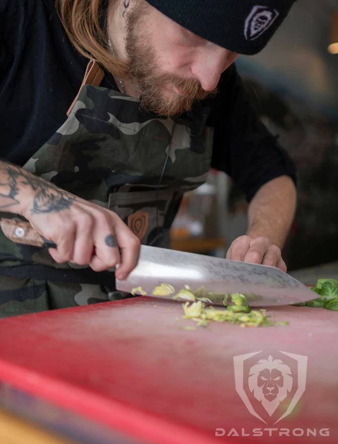 Dalstrong Firestorm Alpha Series Chef knife being used to cut vegetables on a red cutting board