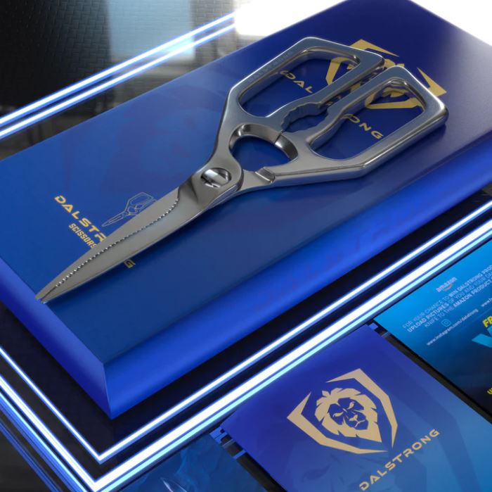 Dalstrong kitchen shears on top of its luxurious blue packaging