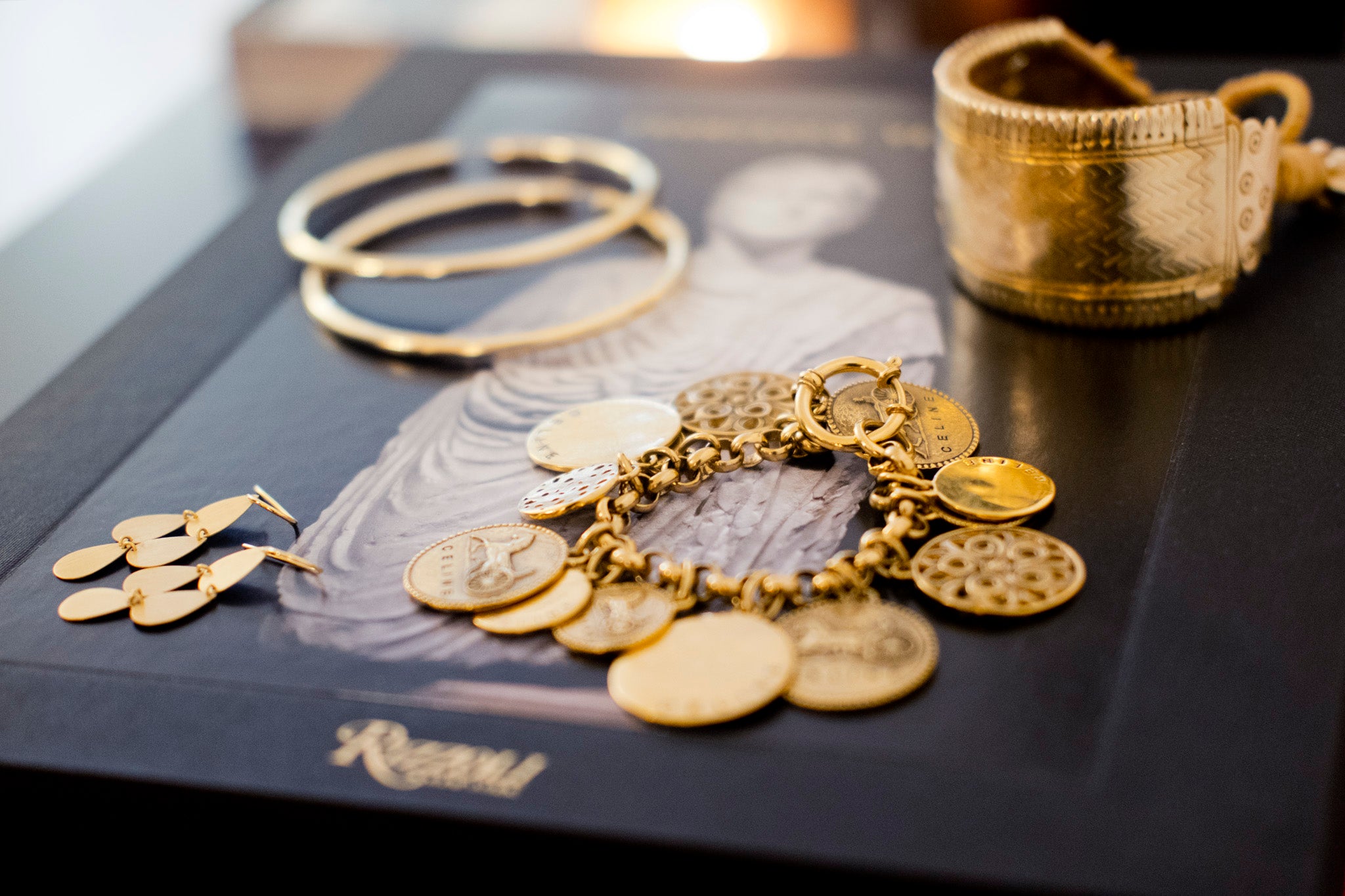 celine khavarani's gold jewelry laid out on black background