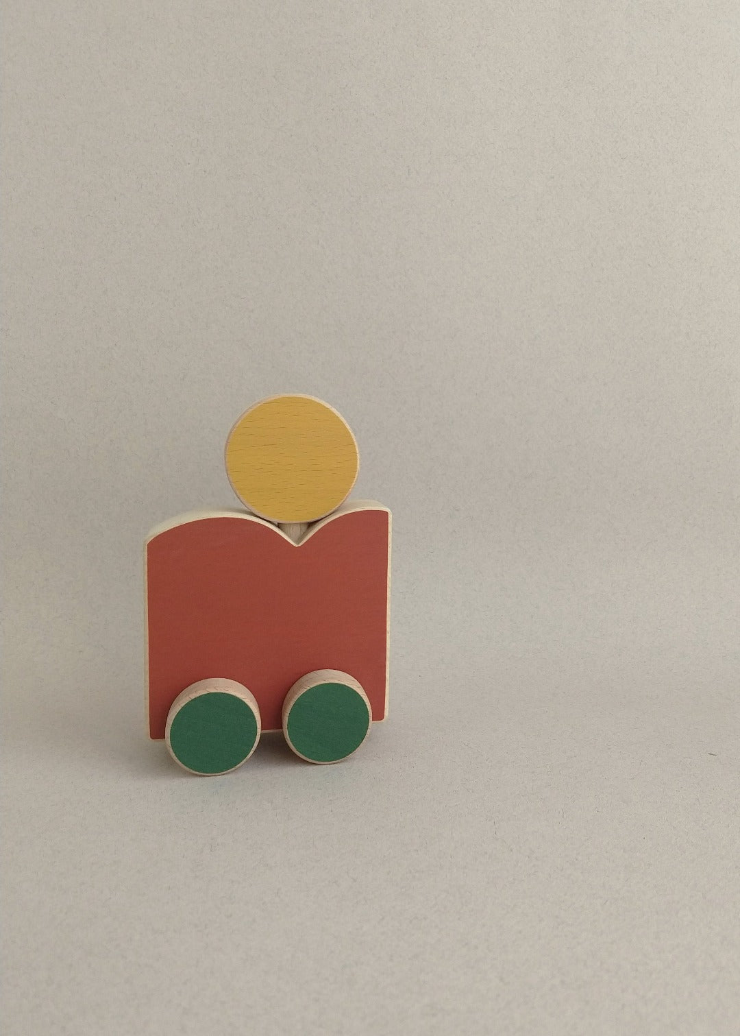 A high-quality & eco-friendly wooden toy on wheels (with a mountain and a sun) drawn from the world of illustration.