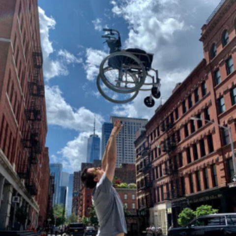 Man throwing the Feather Lightweight Wheelchair in the air