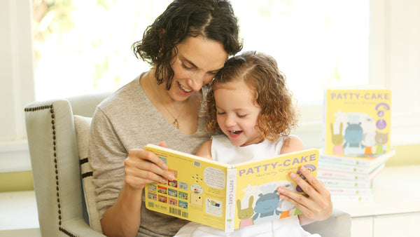 A Mom and her young daughter are reading a book together. Children books, fun activities, educational.