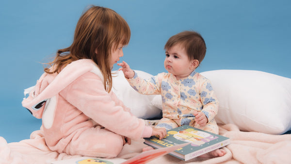 A toddler is playing with a baby and reading books. Bedtime stories, kids activities, educational.