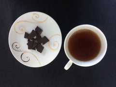 Cup of tea and plate of broken chocolate