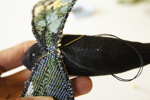 close up of the lower edge of upper wings being hand stitched to the body