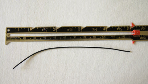 seam gauge on surface with a 5 inch length of cotton cord