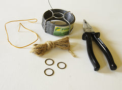 phot of a coil of wire, a skein of hemp cord, three small metal rings and one pair wire clippers