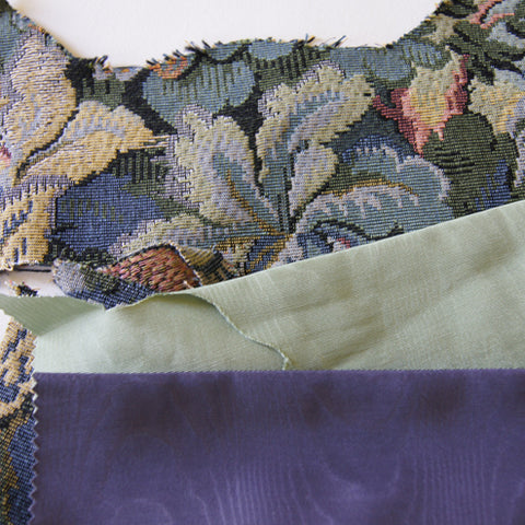 blue tapestry fabric next to remnants of dark blue and light green satin
