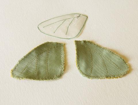 two underwings pictured with veins stitched and the paper pattern lying above them