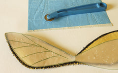 one sheet blue dressmakers tracing paper, a tracing wheel, the upper wings and the wing pattern