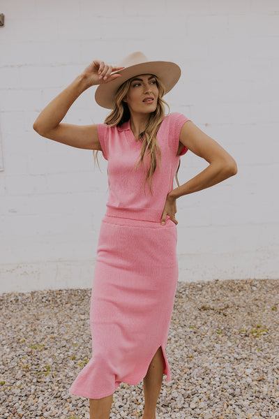 Model wearing a bright pink vest + skirt combo