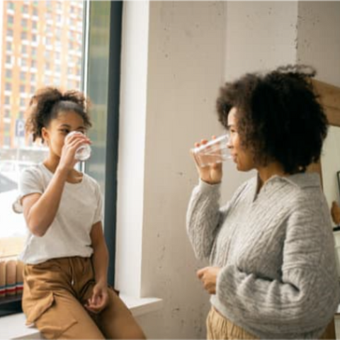 Mother and daughter drinking water
