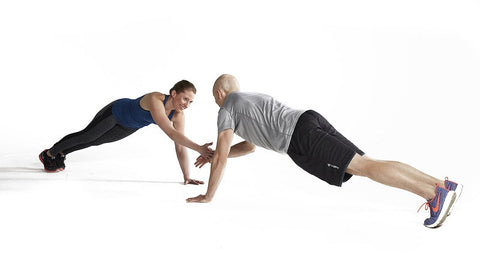 couple facing each other does plank taps