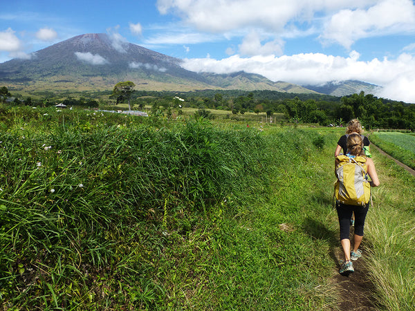 Woman and daughter hike towards a mountain